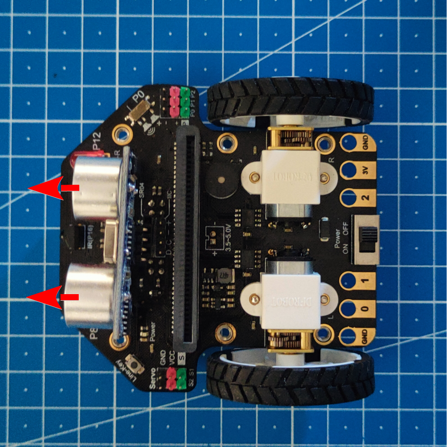 Imagen donde se muestra la placa con las ruedas y el sensor ensamblados. Además, dos flechas rojas indica la posición de montaje del sensor.